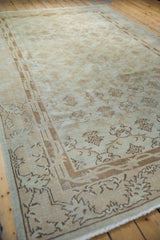 Distressed Turkish Sparta carpet corner with pale coffee bronze and ivory floral motifs.