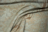 Folded vintage distressed Sparta carpet showcasing soft beige and ivory floral patterns.
