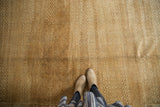 Distressed Oushak carpet featuring worn texture, subtle lattice pattern, and soft beige tones.