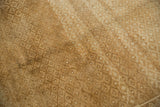 Close-up of distressed vintage Oushak carpet, showing intricate lattice, warm neutral tones, and texture.