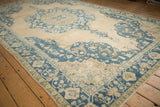 Distressed Sivas carpet corner displaying intricate denim blue, ivory, and coffee brown floral borders.