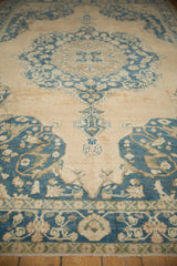 Distressed vintage Sivas rug detail featuring dusty teal and pale apricot floral motif.