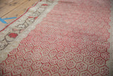Distressed cherry red diminutive boteh motifs and antique ivory border of this Oushak runner.