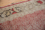Distressed cherry red Oushak rug runner detail showing boteh motifs and light foundation.