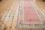 Distressed Turkish Oushak runner, angled view showing cherry red boteh pattern and wear.