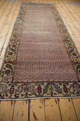 Vintage distressed Oushak runner showing faint foundation, raspberry lattice, and meandering vine border.