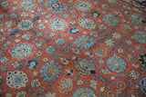 Vintage Tabriz carpet's Safavid palmette and lotus pattern in brick red, blue, and ivory.