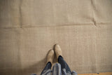 Vintage distressed Oushak carpet showing neutral sand and antique ivory tones and textured wear.