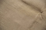 Distressed sand and beige Oushak rug texture with visible knot heads and subtle foundation.