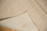 Distressed vintage Oushak pile revealing textured neutral tones, woven reverse, and short fringe.