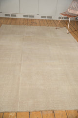 Distressed Oushak carpet texture with even wear in sand and antique ivory.