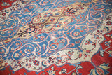 Distressed Laristan carpet with textured low pile, sky blue scrolling tendrils, and red arabesques.