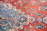 Vintage distressed Laristan carpet showing cherry red field, navy blue arabesques, and delicate floral vinery.