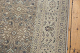 Distressed vintage Sparta carpet displaying intricate floral field and lighter antique ivory border.