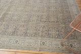 Distressed floral pattern and decorative border of a vintage Sparta carpet in muted tones.