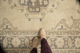 Distressed Turkish Oushak rug border, geometric motifs in ivory and charcoal, with a textured pile.