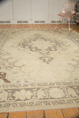 Geometric border of a distressed Turkish Oushak carpet with time-softened tones and visible wear.