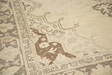 Ivory and brown geometric arabesque corner, showcasing distressed pile texture and foundation wear.