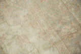 Distressed pile of Sivas carpet showing decorative worn texture, muted green and ivory.