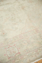 Distressed vintage Sivas rug detail, showing worn ivory pile with pale rose and green motifs.