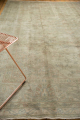 The distressed Sivas carpet's faded floral tendrils in soft pale terra cotta and sea foam.