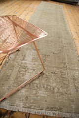 Distressed Oushak runner end, showcasing soft antique ivory and sand tones, with short fringe.