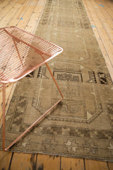 Distressed Oushak runner with primitive geometric guls in warm beige and brown tones.