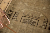 Primitive geometric pattern of a distressed Oushak runner in beige and chocolate brown.
