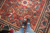 Vintage Mahalati carpet's low pile, cherry red field, and ornate floral tendrils.