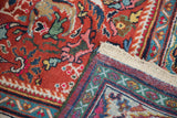 Hand-knotted vintage Mahalati carpet detail: red field, scrolling florals, colorful borders, and ivory fringe.