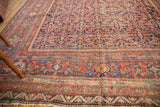 Antique Mahal carpet corner detail: intricate madder red and indigo blue floral border, low pile.