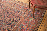 Corner of an antique Persian Mahal carpet, showing madder root red border with herati field.