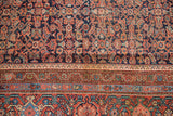 Antique Mahal carpet: herati field and ornate borders in madder red, navy, sky blue, copper green.