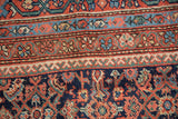 Close-up of antique Mahal rug's hand-knotted herati motif in madder red and indigo.