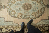 Distressed vintage Oushak carpet showing soft scalloped medallion with even wear and pastel tones.