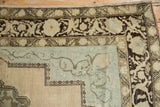 Distressed vintage Oushak corner with faded pale blue field and dark brown border.