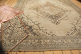 Oversized medallion, scalloped contour, and germinating plant motifs on a distressed Oushak.
