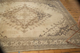 Floral border motifs and an antique ivory field on the distressed vintage Oushak rug.