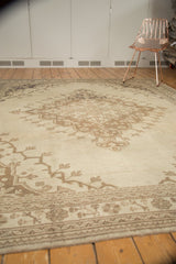 Vintage distressed Oushak rug, corner showing muted ivory and brown tones, subtle motifs, and secure edge.