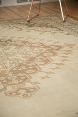 Distressed texture on the ivory and brown scalloped medallion of a vintage Oushak rug.