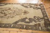 Distressed Oushak rug corner with time-softened brown patterns on an antique ivory field.