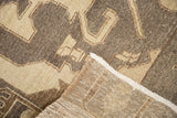 Folded corner of a distressed vintage Oushak rug, showing its hand-knotted foundation and subtle wear.