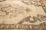 Distressed vintage Oushak rug corner with coffee brown border and stylized patterns.