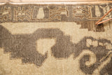 Distressed vintage Oushak rug displays sharply contoured beige and coffee brown geometric motifs.