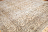 Distressed Sivas carpet detail showing faded floral vinery, palmettes, and arabesque border.