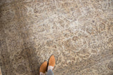 Faded beige and brown floral vinery on a distressed vintage Sivas carpet.