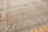 Distressed vintage Sivas rug showcasing muted floral vinery and worn, time-softened neutral pile.