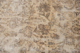 Distressed texture of vintage Sivas carpet showing faded beige, sand, and brown floral vinery.