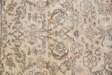 Allover vinery, palmettes, and blossoming floral design in distressed beige and brown tones.