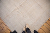 Distressed vintage Oushak carpet with low pile texture and subtle ivory, beige, sand tones.